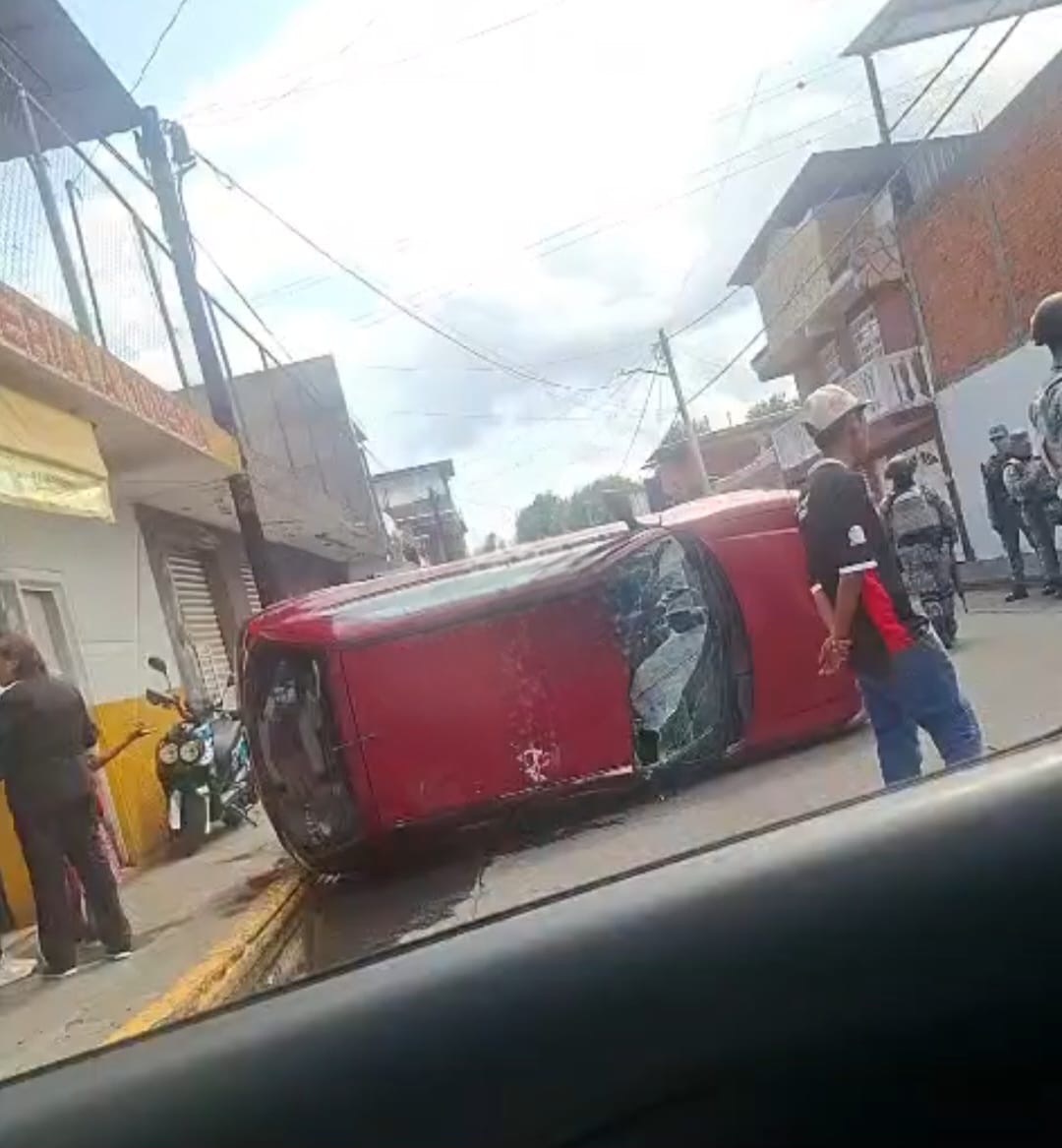 Vehículo estacionado vuelca tras ser "enganchado" y arrastrado por camión de carga, al oriente de Uruapan